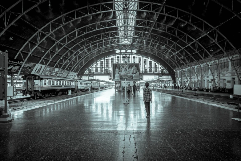 a man walking down a train platform next to a train