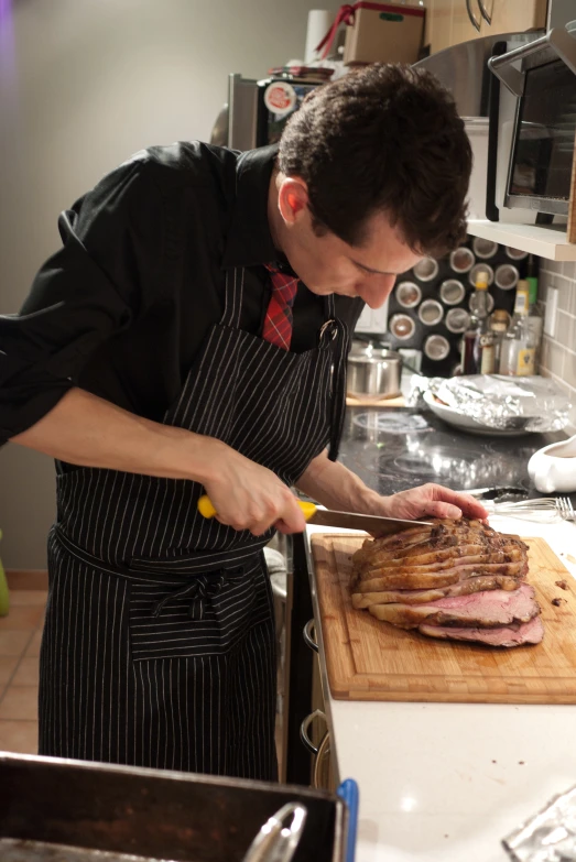 a man in an apron cuts up a hamburger