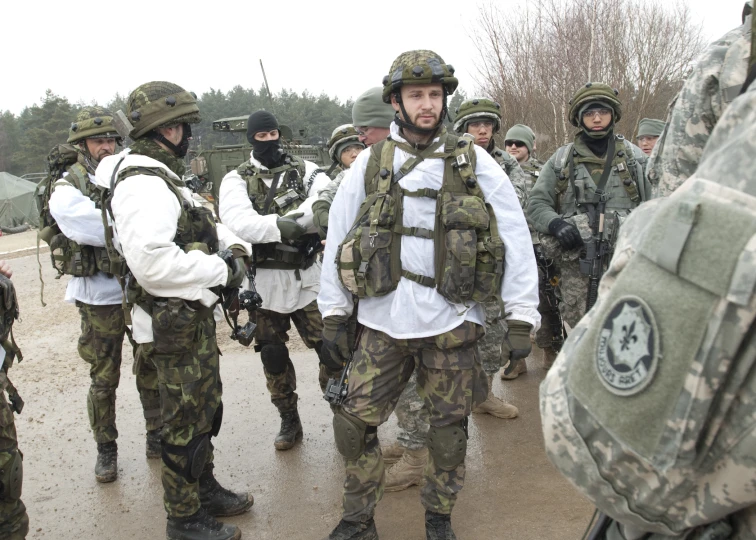 some military personnel talking with each other on the road