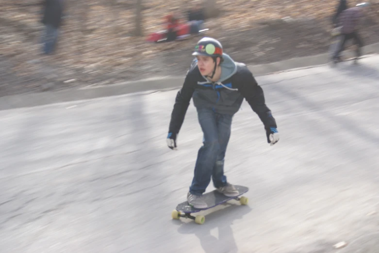 a boy skateboarding on a street, on the pavement