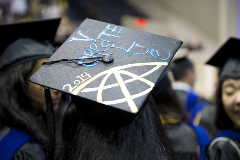 students wear their caps with blue writing on them