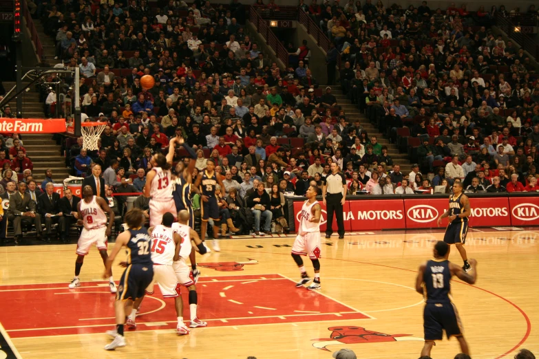 a basketball game that has many players and spectators