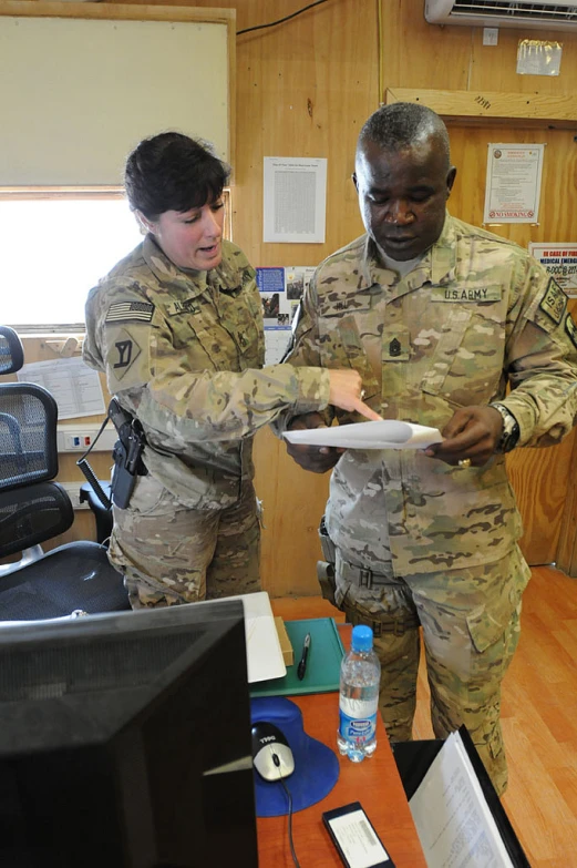 a woman with a man in a uniform are checking soing