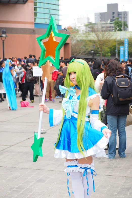 a young lady in a cosplay costume holding a star sign