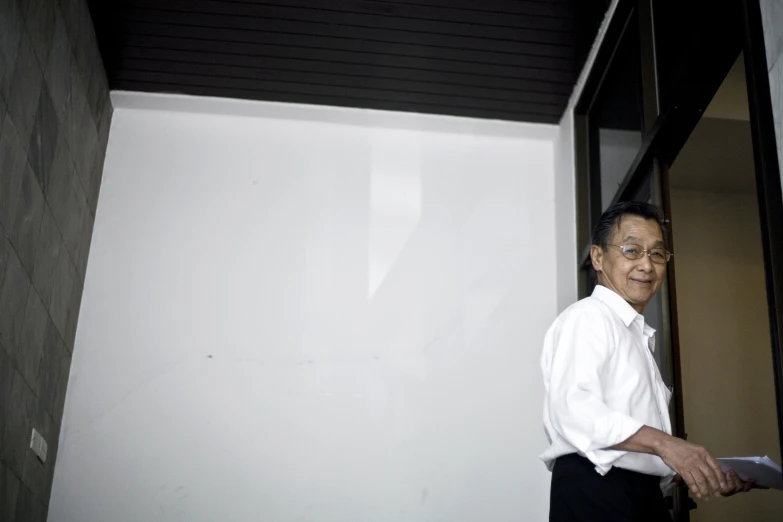 a man in a white shirt standing outside of a building