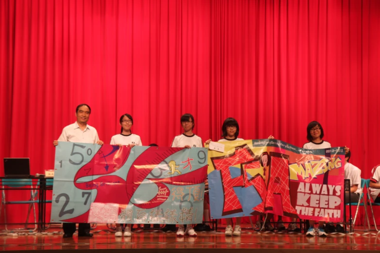 a group of people standing next to a red curtain