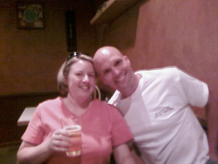 man and woman posing for a picture in front of some booths