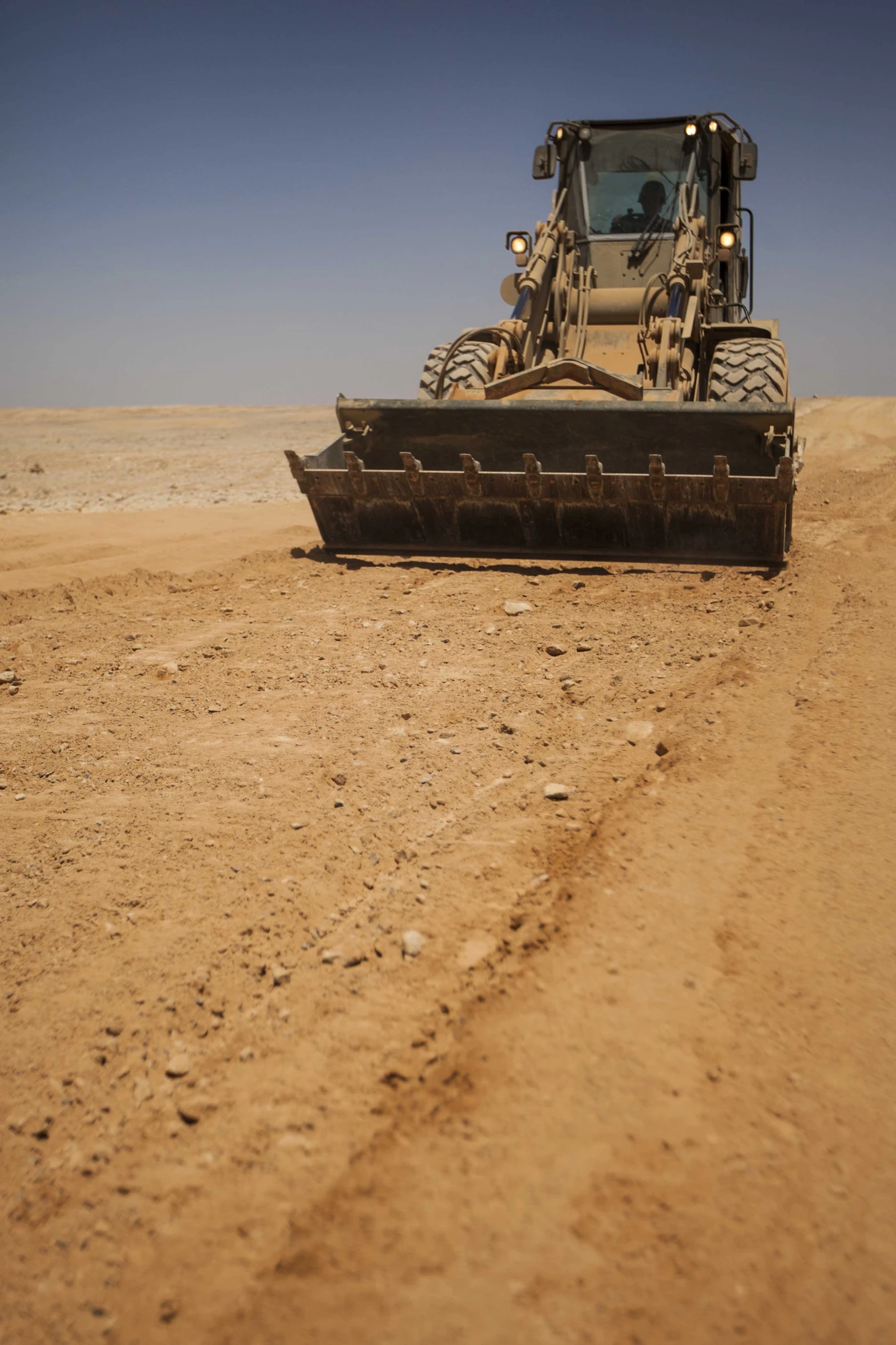 a tractor driving on the road in the desert