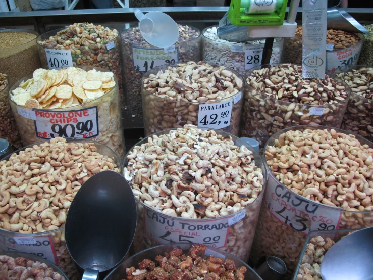 containers are filled with nuts and there are spoons