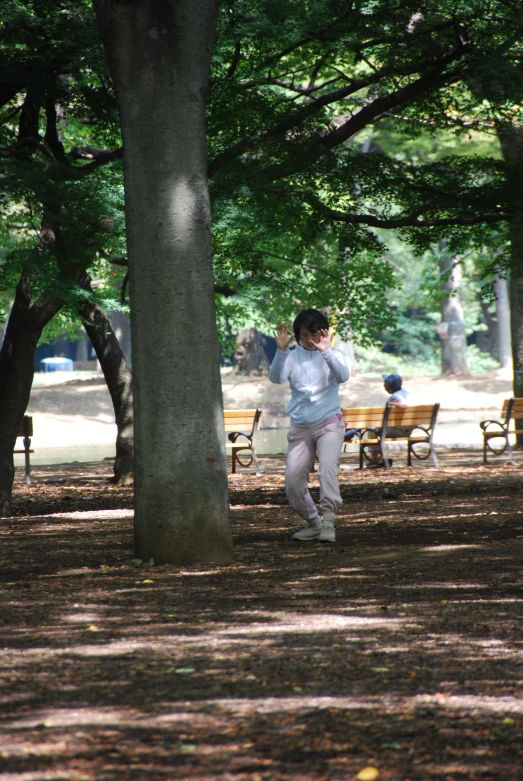 woman in park with tennis racket in her hand