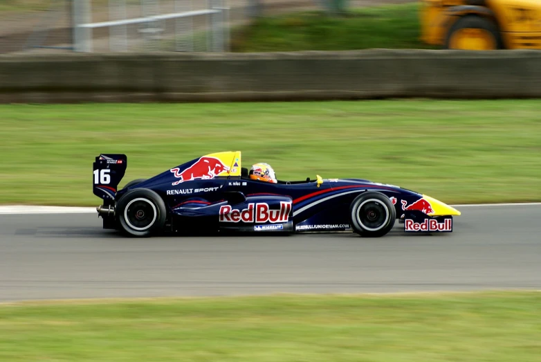 a man driving a red bull car on a race track