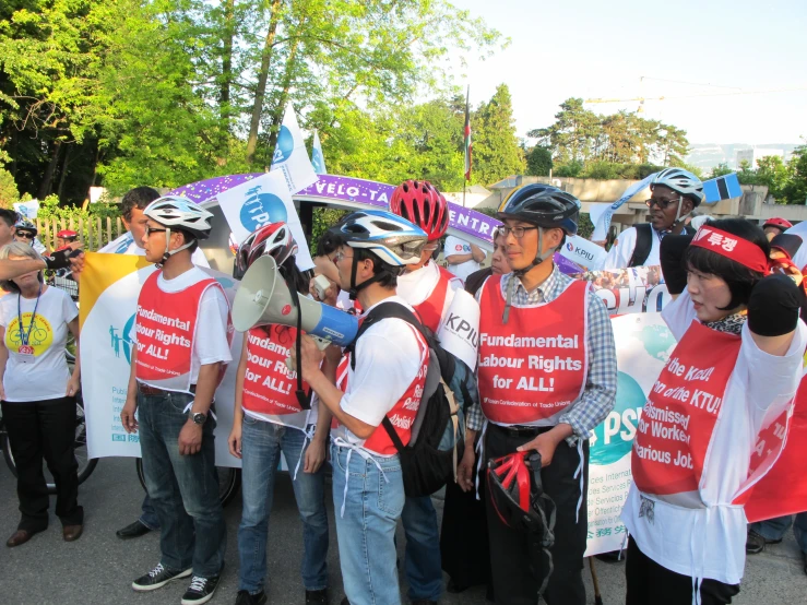 several people are gathered together holding signs and hats