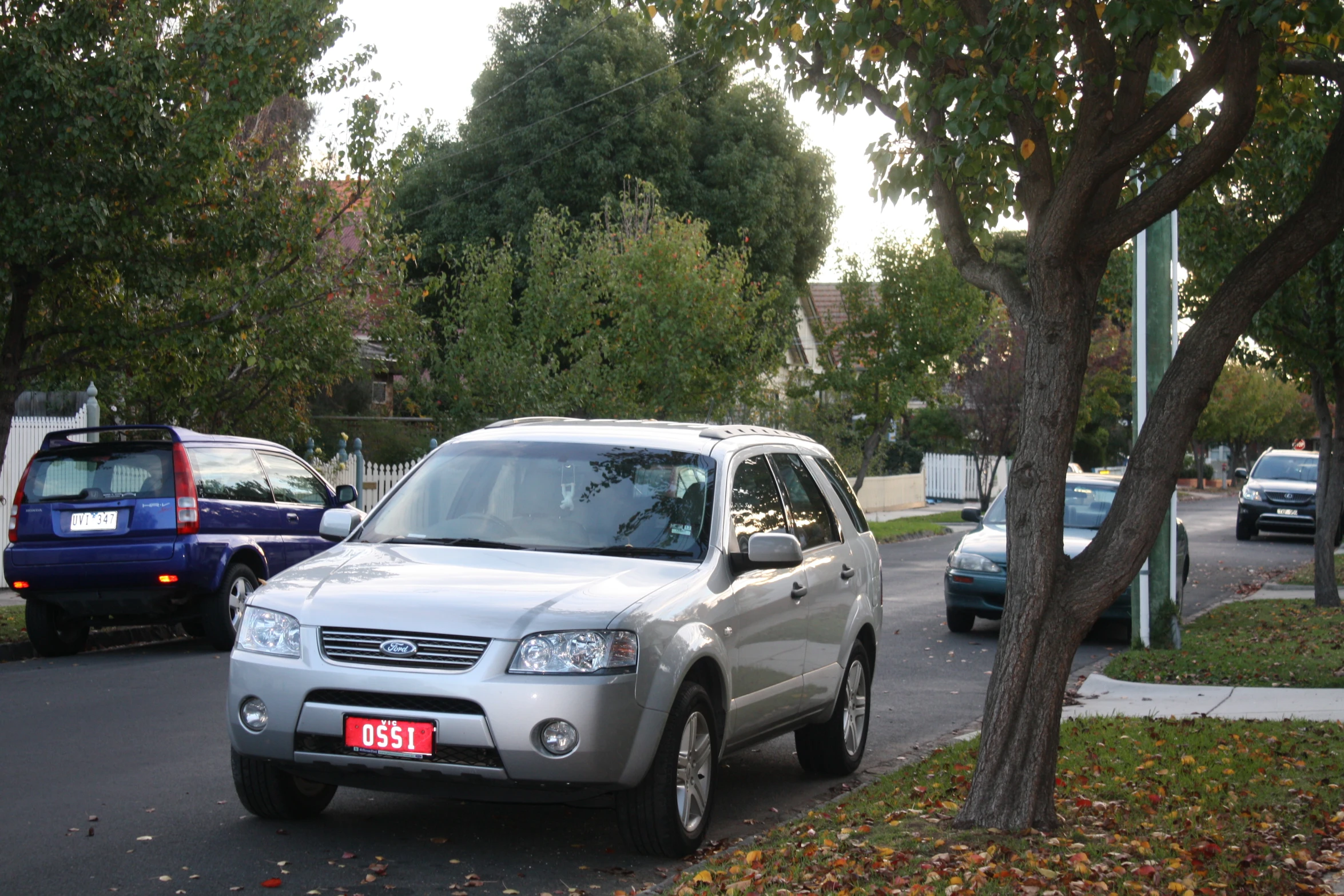 the silver suv is parked on the street