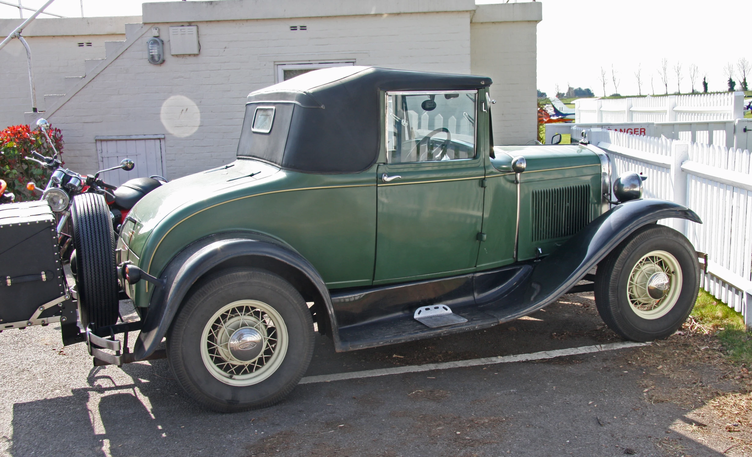 an old, classic green truck is parked outside the motel