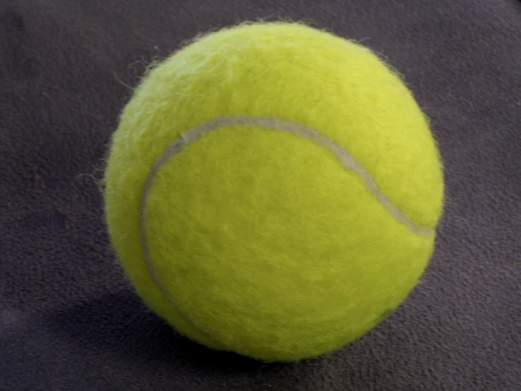 the tennis ball has just been cleaned and is on top of the carpet