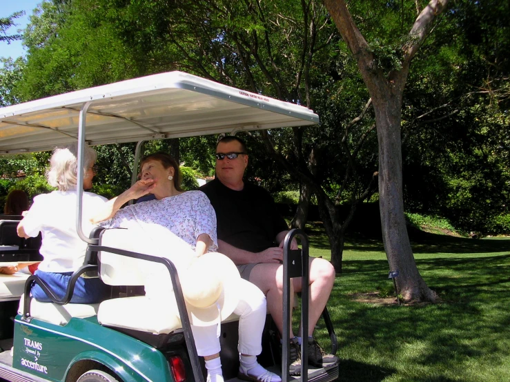 a group of people on a green golf cart