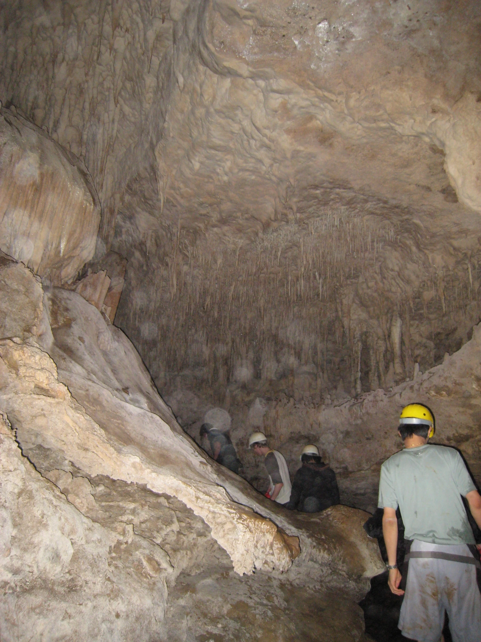 men are climbing up some rocky and narrow cliffs