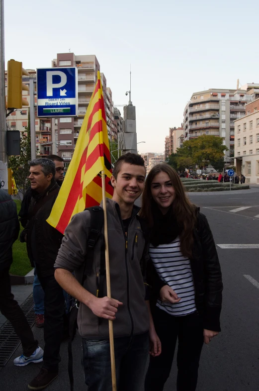 people standing around a street with signs and a flag