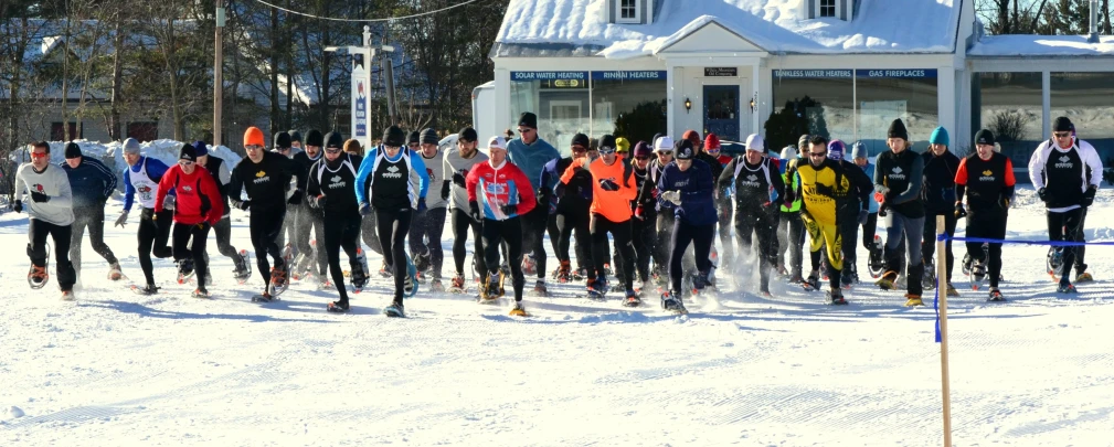 a group of people racing across snow covered ground