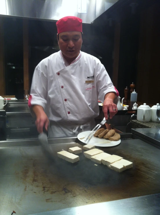 a chef with a red chef's hat is  food on the plate