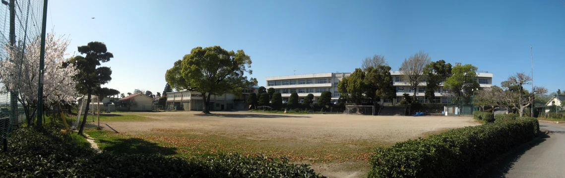 a building sits behind a fence in the middle of the field