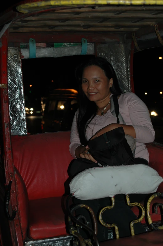 woman smiling and riding a small bus at night