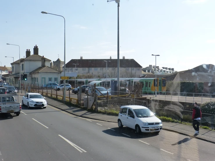 cars and people are walking on the side of a road