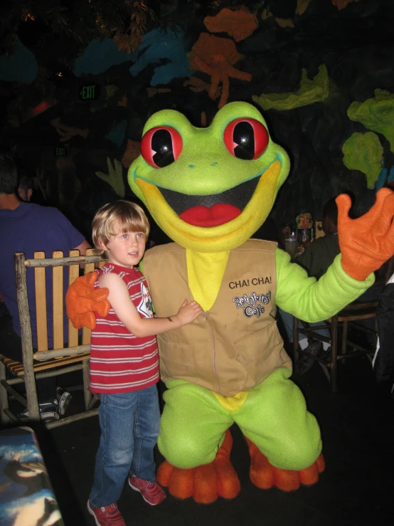  standing next to a stuffed frog with hand up