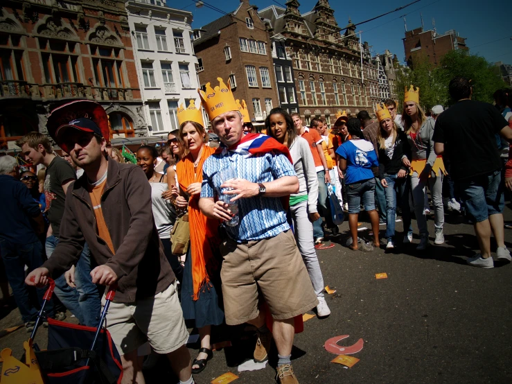 a crowd of people standing on a street while wearing costume
