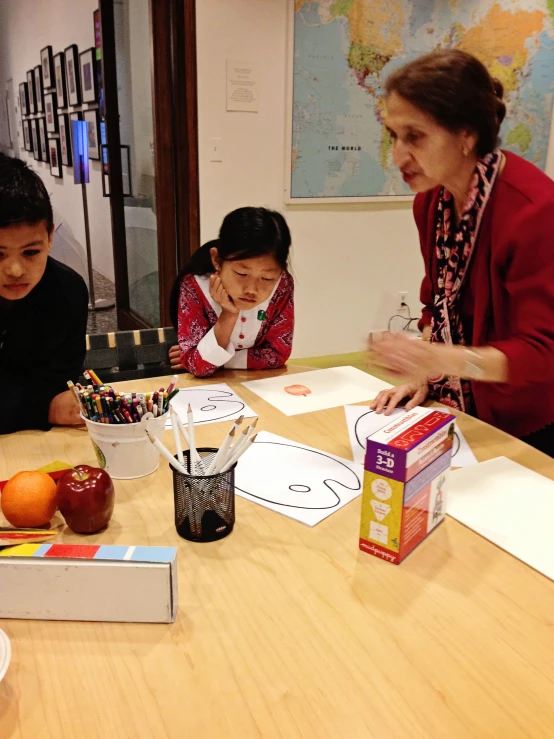 a woman and two boys are at a table