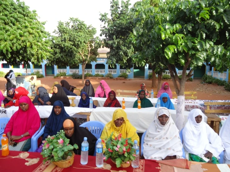 group of women sitting at long tables with flowers and drinks