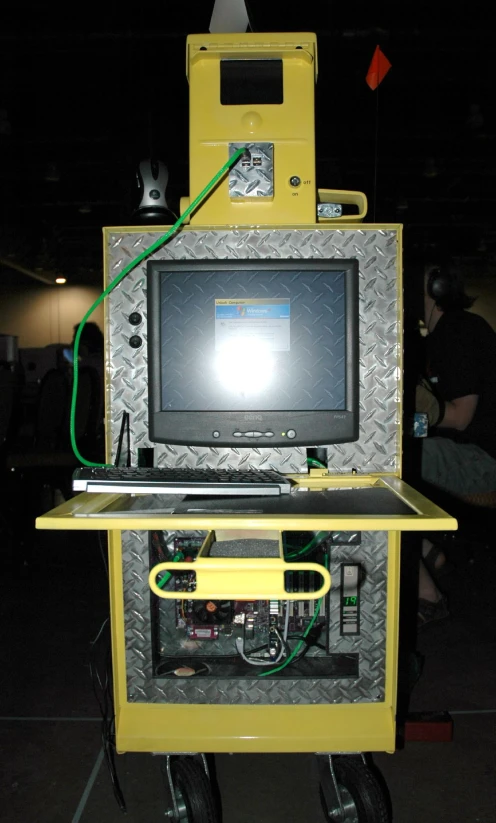 a tv monitor is mounted on a yellow box