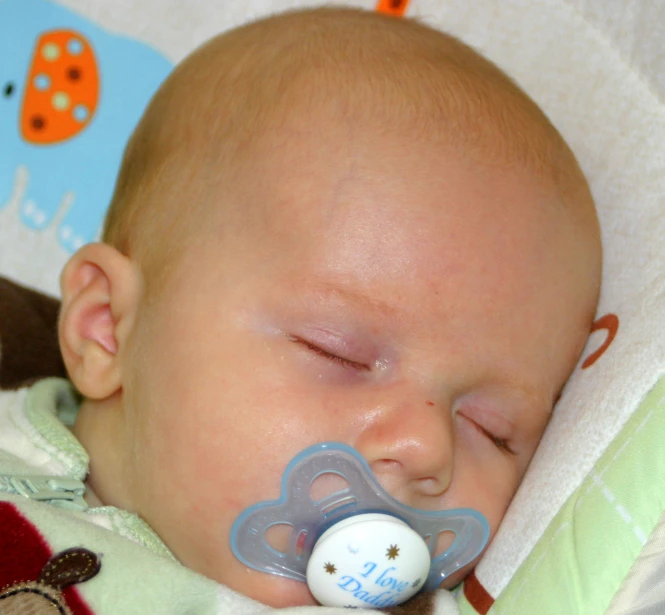 an infant in a blanket with a pacifier in its mouth