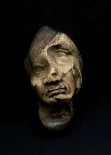 a wood mask is shown on display against a dark background