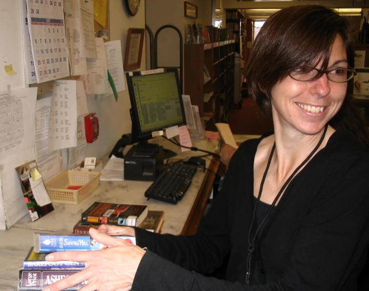 a woman is sitting at a table with some books