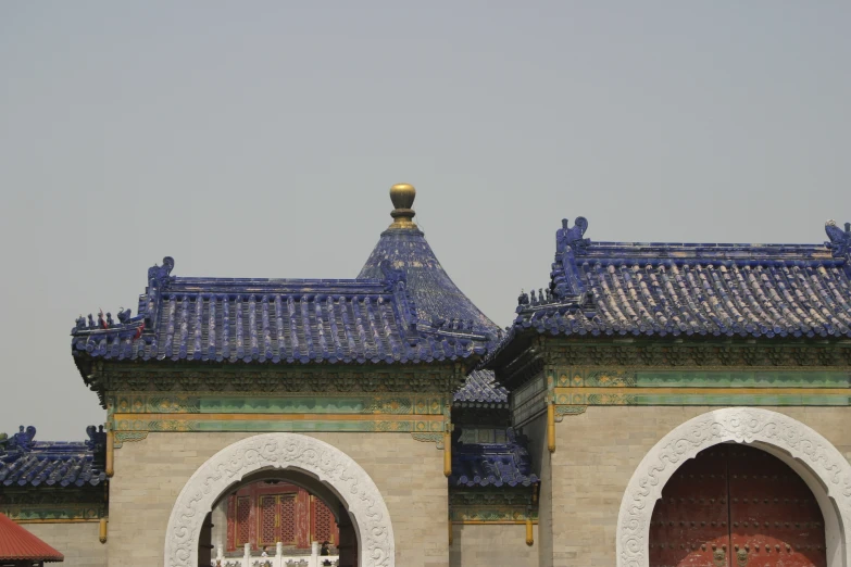 a large wall with arched doorways and blue tiles on it