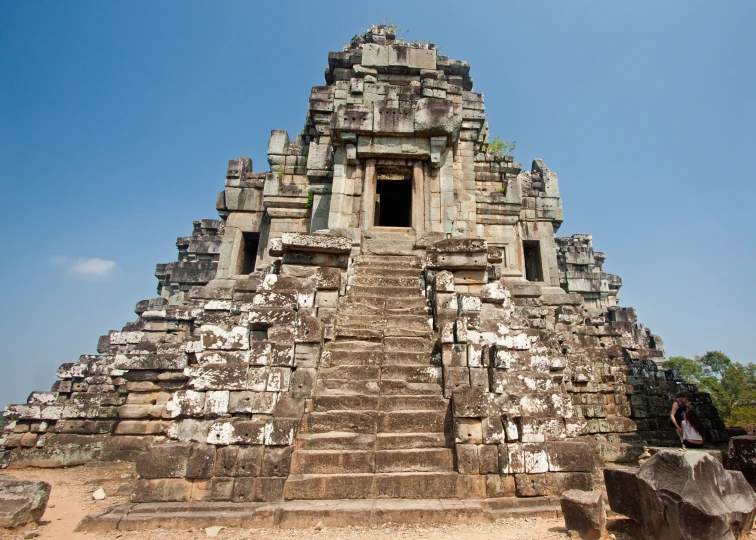 an ancient structure on the ground in front of a blue sky