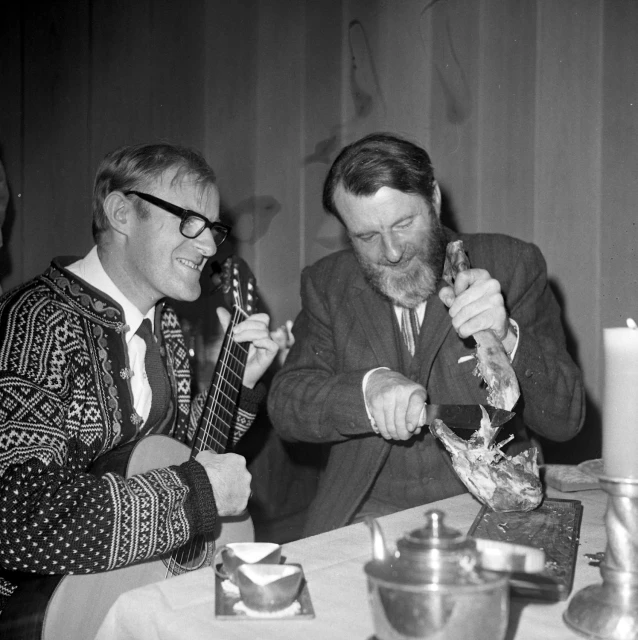 a man getting ready to eat while another mans sits at the table