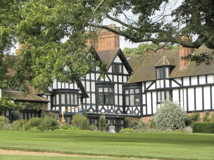 the building with lots of windows is situated among the green