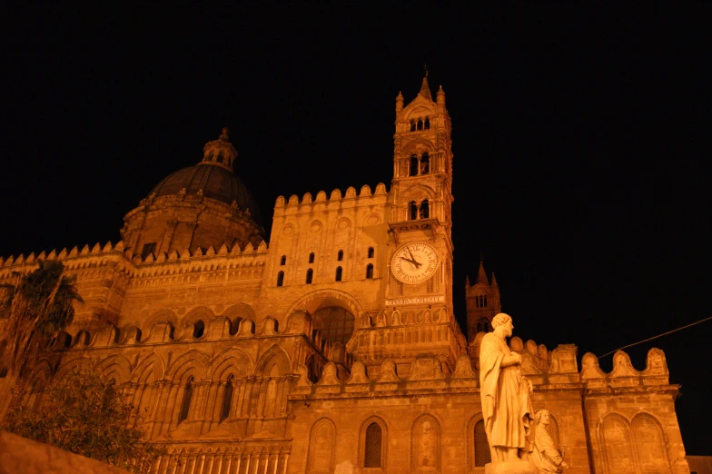 a castle with a clock and statue on it