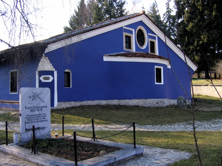 a large blue building with three windows and no one sitting on it