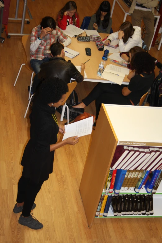 a group of students sitting around a table in an open classroom