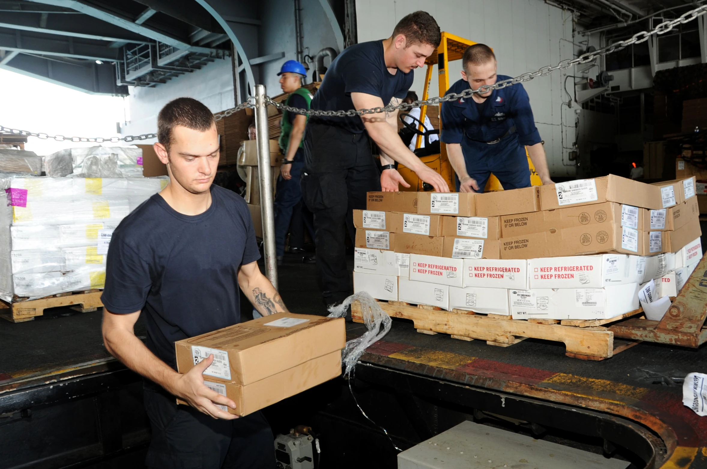 several men unload and unpack boxes from a truck