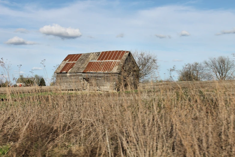 an old shack sits abandoned in a field