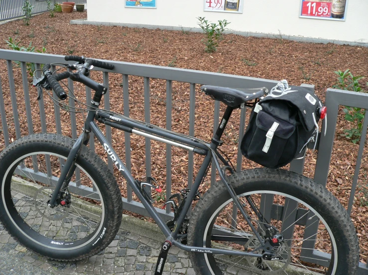 the bicycle is parked by the fence outside