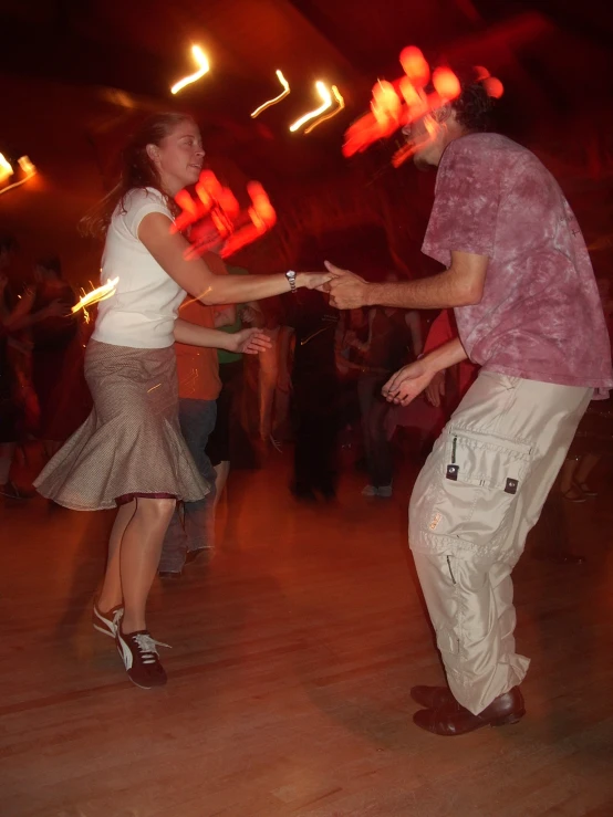 two people are dancing on the dance floor in a ballroom