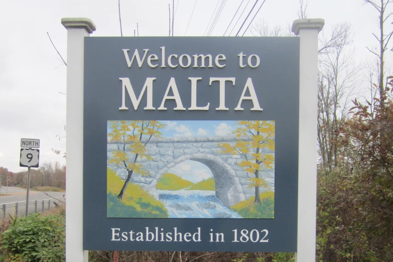 sign with picture of river underneath and bridge with text welcome to malta established in 1932