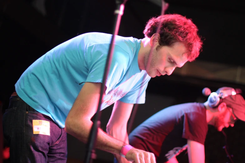 two men standing together as one is typing on a keyboard