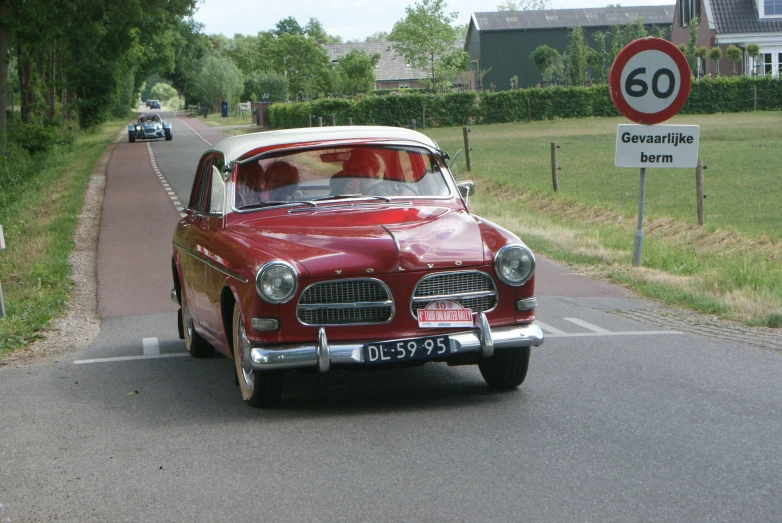 a car drives on a road with two speed signs