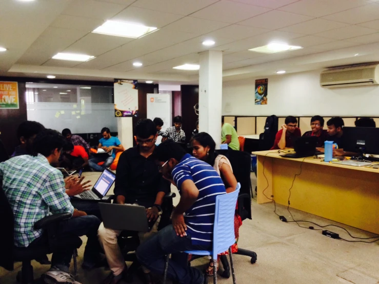 several people in a room using laptops